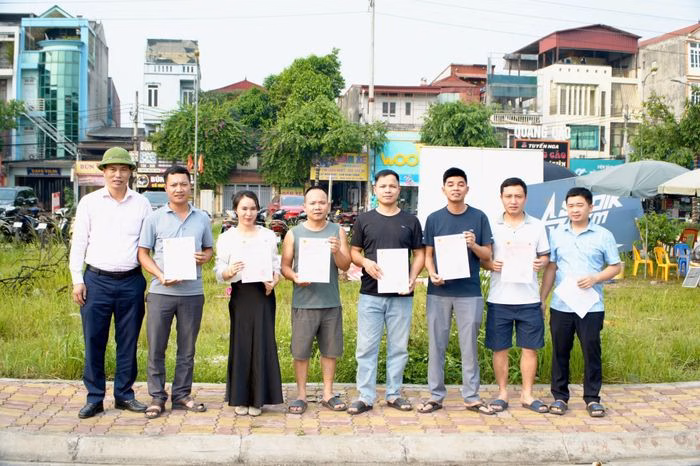 Ông Trần Văn Hòa, Phó Trưởng phòng kinh tế xã Tây Phương trao giấy chứng nhận quyền sử dụng đất cho các khách hàng hoàn thành nghĩa vụ tài chính. Ảnh: Hữu Dũng