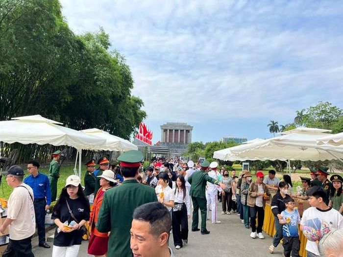 Rất đông khách tham quan đi qua khu vực nhận nước và bánh mỳ miễn phí trong không khí trật tự, văn minh.
